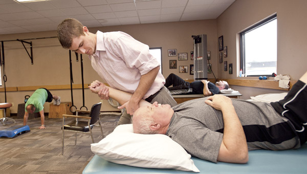 Chase Higgins, physical therapy assistant, works on a patient at Tri-State Rehab Services on South Third Street in Ironton.