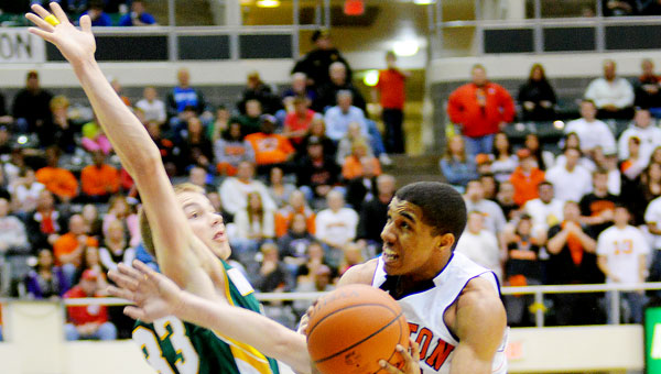 Ironton’s Zac Carter drives to the basket and finishes through contact. The Fighting Tigers hammered the North Adams Green Devils 80-33 in the Division III district semifinals Saturday at Ohio University’s Convocation Center.
