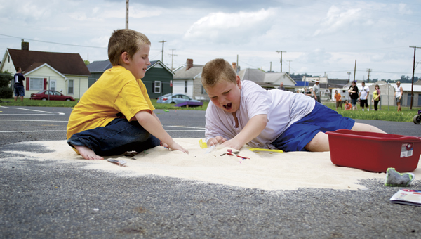 Amos Bryant, right, digs in sand for treasure with his friend during the Open Door School’s Fun Day on Wednesday.