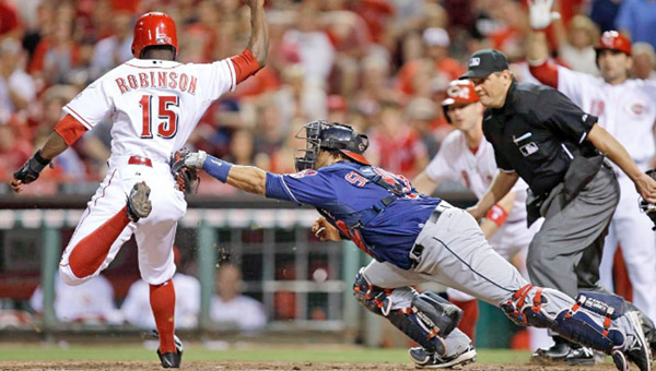 Cincinnati’s Derrick Robinson (15) is tagged out at home by Cleveland catcher Carlos Santana during the seventh inning of Tuesday’s game. The Reds won 8-2. (Photo Courtesy of The Cincinnati Reds)