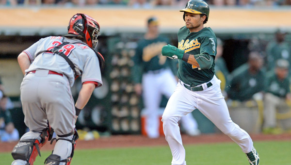 Cincinnati catcher Ryan Hanigan (29) watches as Oakland Athletics’ Coco Crisp (4) scores on a single hit by Yoenis Cespedes in the second inning of Tuesday’s game against the Cincinnati Reds in Oakland, Calif.. The A’s beat the Reds 7-3. (MCT Direct Photo)