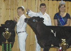 Kaylee Cade, 11, won grand champion and junior showmanship honors in the dairy cattle category. Her brother, Uriah, won reserve champion. Also pictured is Lawrence County Fair Queen Skye Barnett.