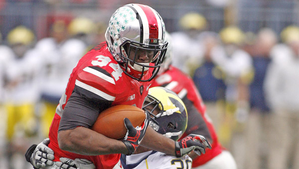 Ohio State's Carlos Hyde (34) is shown trying to break free from Michigan's Thomas Gordon (30) during the second half of a game last season. Hyde — the team’s leading scorer last season — is one of four Buckeye players who were disciplined by head coach Urban Meyer for off the field legal issues. (MCT Direct Photo)