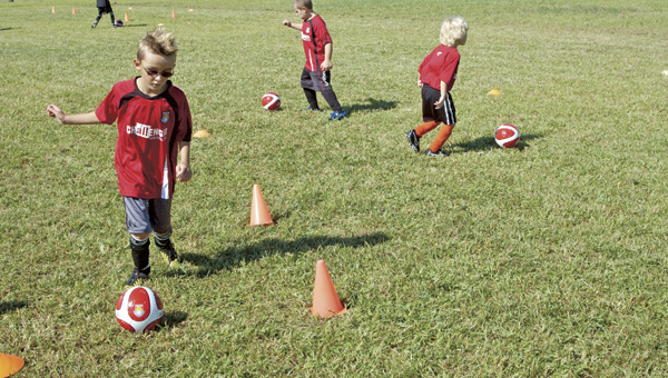 Carter Collins practices dribbling during the first day of soccer camp at Ohio University Southern Proctorville Center on Monday.