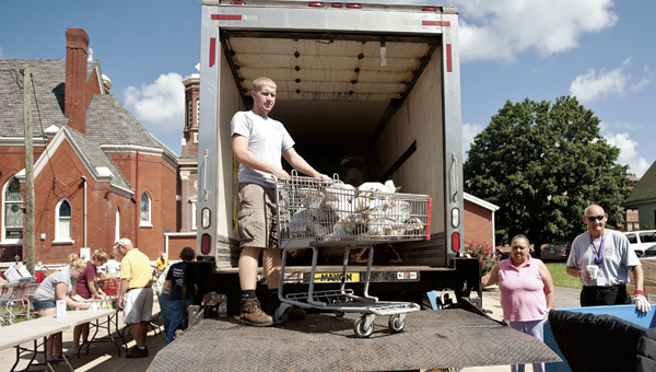 Christopher McClurg unloads sacks of potatoes off the Lutheran Social Service Mobile Food Pantry Truck Thursday morning outside of St. Paul Lutheran Church.