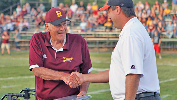 Russell Red Devils’ longtime head football coach shakes hands with Ironton Fighting Tigers’ head coach Mark Vass during a presentation prior to last Friday’s game. McGlone was given a plaque in appreciation for his 38 years as a head coach and for helping to keep the Ironton-Russell rivalry alive. The plaque was presented on behalf of the Ironton fans, coaches and Tiger Clan booster club. McGlone has more than 300 career wins and he has guided the program to a pair of state championships. (Courtesy of Tim Gearhart of Tim’s News & Novelties In Ironton)