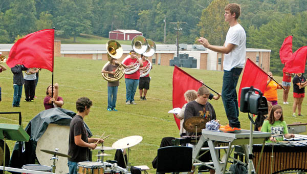 Rock Hill High School band director Nick Basham, on the wooden platform, observes the “Pride of Lawrence County” during practice Wednesday. The Redmen are preparing for Saturday’s Rock Hill Band Invitational, a competition returning after a 13-year hiatus.