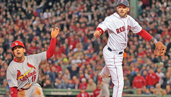 Jon Jay, left, of the St. Louis Cardinals and Boston Red Sox third baseman Xander Bogaerts watch an errant throw from pitcher Craig Breslow sail into the outfield, which allows Jay to score in the seventh inning in Game 2 of the World Series at Fenway Park in Boston on Thursday. he Cards rallied for a 4-2 win. (MCT Direct Photos)