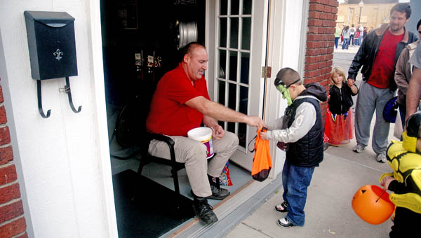 Charlie Haas, owner of Charlie’s Tire Sales in Ironton, hands out candy during Safe Trick or Treat on Monday.