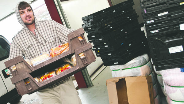 Todd Turkhorn hauls crafts of bread from the back of a truck to be given away during the Thanksgiving basket giveaway at Harvest for the Hungry.
