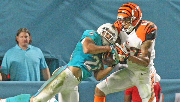 The Miami Dolphins’ Brent Grimes, left, intercepts ball intented for Cincinnati Bengals’ wide receiver Marvin Jones during the third quarter at Sun Life Stadium in Miami Gardens, Fla, on Thursday. Bengals’ quarterback Andy Dalton was intercepted three times and sacked in overtime that gave the Dolphins a 22-20 win. (MCT Direct Photos)