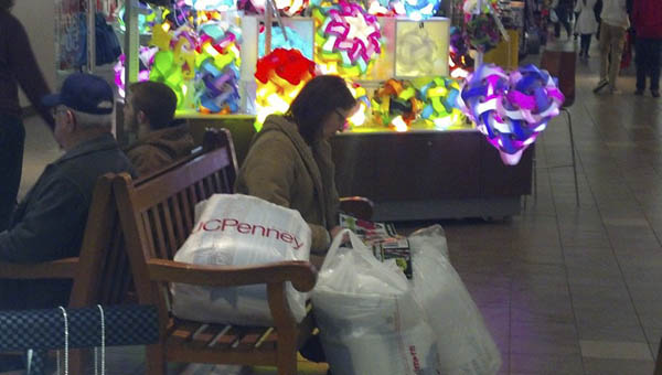 A Black Friday shopper rest on a bench inside the Ashland Town Center Mall. Photo by: The Tribune/Justin Prince
