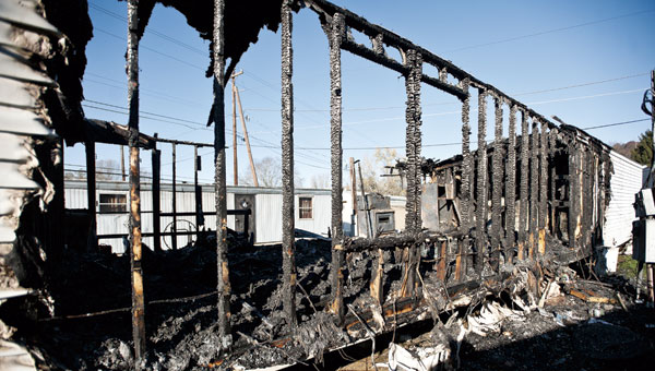 A neighboring trailer can be seen through the charcoaled remains following an early morning fire that destroyed a mobile home in the Sheridan Area. No injuries were reported.