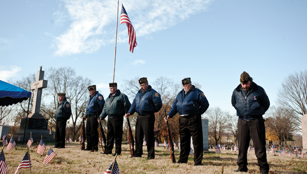 Members of VFW Post 8850 stand with their heads bowed during a benediction given by Chad Pemberton during the annual Veterans Day service at Woodland Cemetery.