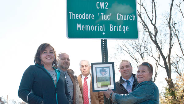 Theodore Church’s widow Mindi Church, left, and other Betty Church, right are seen with all three Lawrence County Commissioners during a bridge dedication in Church’s name Friday. Church died in 2007 while serving in Iraq.