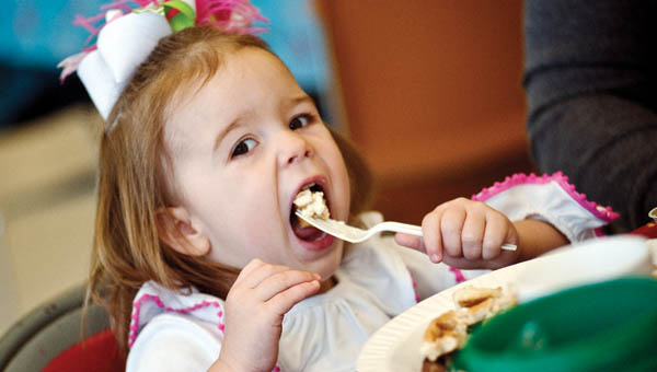 Sofia Sheridan attempts to take in a mouthful of pancakes while attending the annual Kiwanis Pancake Breakfast with Santa event Saturday.