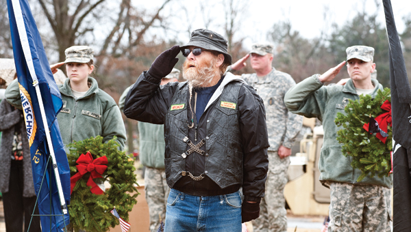 Jim Kelly stands at attention during the playing of the national anthem at the Wreaths Across America ceremony Saturday at Woodland Cemetery.
