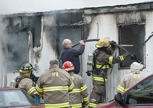 Chief Runyon is seen assisting Ironton fire fighters at a trailer fire located at the Sta-Tan Trailer Park Friday afternoon.