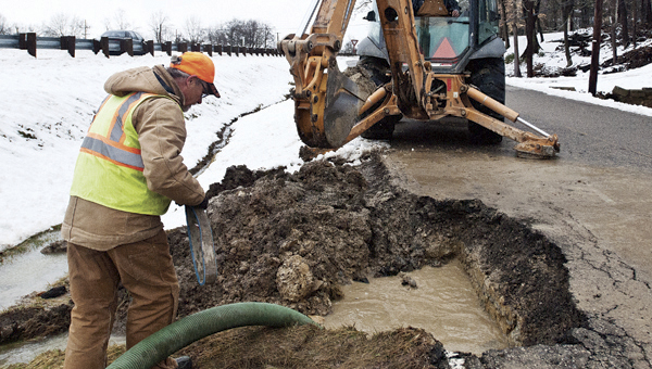 THE TRIBUNE/JESSICA ST JAMES Tim Malone, left, and Joe Johnson, right, with the City of Ironton have been working almost nonstop as they battle broken water lines in the city.
