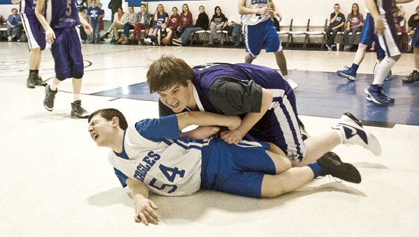 Carter Christian Academy player Nathan Wade falls on Sugar Creek Christian Academy player Seth Nichols during a four-team basketball tournament. THE TRIBUNE/JESSICA ST JAMES