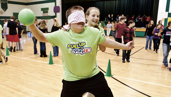 Kelsie Warnock leads Michael Jeffrey around in a game of Tank, a variation of blind man’s bluff, at the Fairland Middle School Fitness Fair Friday. THE TRIBUNE/JESSICA ST JAMES