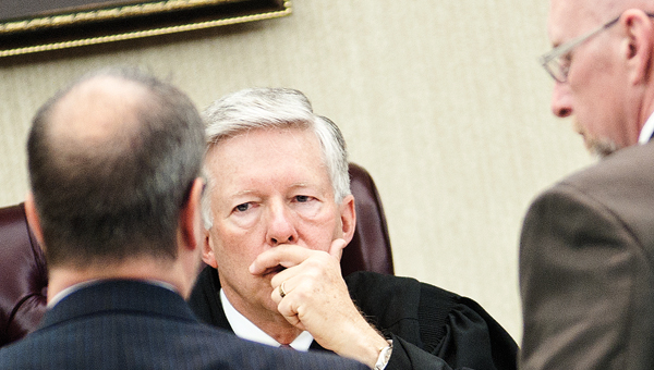 udge Charles Coopers convenes in a sidebar with attorneys Brigham Anderson, left, and Mike Davenport, right.