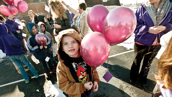 James Hall waits anxiously for the annual balloon launch at Open Door School. (BELOW) Students and faculty let their balloons fly.