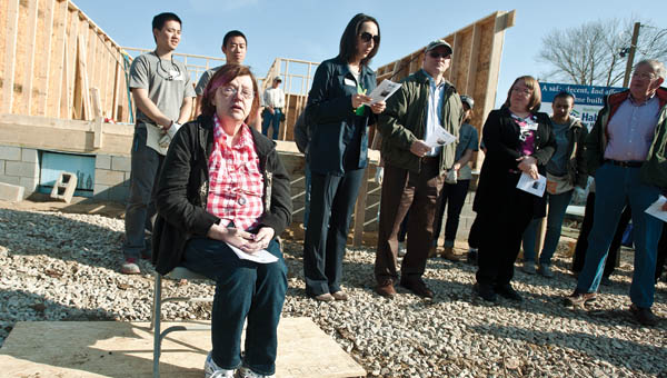 Linda Dennison, seated, holds back the tears as Gary Prater performs the song “Habitat, It’s You and It’s Me” during a wall-raising ceremony in Miller on Friday.