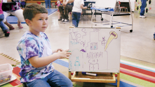 The Tribune/Justin Prince Tyson Lewis, a 5-year-old student at the Lawrence Street Center, draws a picture from a scene in Batman for the school’s art show.