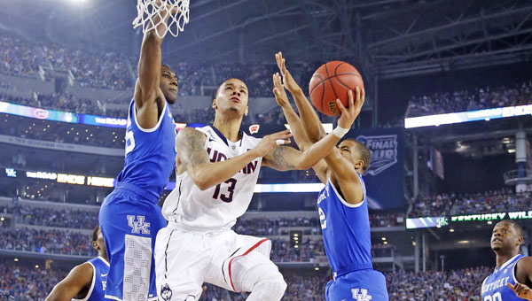 Connecticut’s Shabazz Napier (13) takes it to the basket through Kentucky’s Dominique Hawkins (25) and Aaron Harrison (2) in the first half as the Kentucky Wildcats faced the Connecticut Huskies in the NCAA Final Four championship game at AT&T Stadium in Arlington, Texas, Monday. The Huskies won the national title 60-54. (MCT Direct Photos)