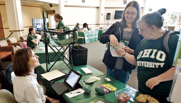 Roxann Gool, left, and Cheryl Hamilton, right, speak with Eva Bloom with Ohio University Credit Union during the grad fair in the school’s Mains Rotunda.