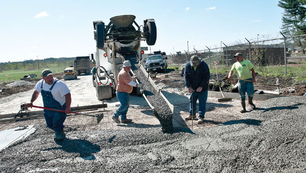 Employees from Mullins Construction lay cement at the new entrance, located along Sixth and Lorain streets.
