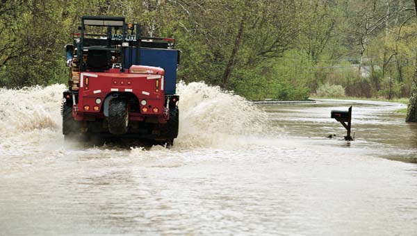THE TRIBUNE/JESSICA ST JAMES A hauling truck braves the high waters while traveling northbound on State Route 93 in Pedro Wednesday.