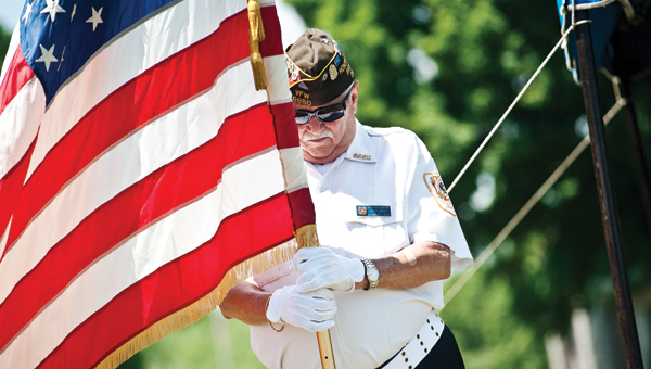 Bennie Blankenship held the American flag with his head bowed during the invocation at the Veterans Memorial Service at Woodland Cemetery Sunday afternoon.
