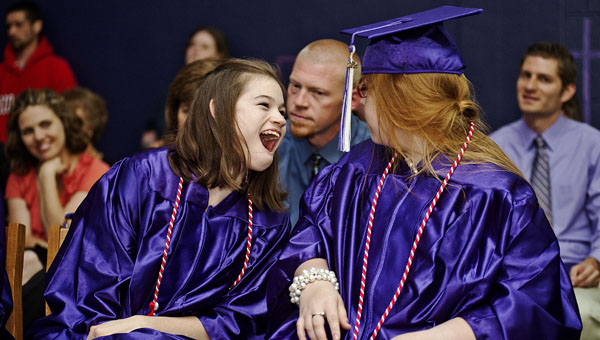 Chelsea Little, left, gives her classmate Kayla Sharp, right, a big smile during graduation ceremonies at Open Door School Thursday at the school