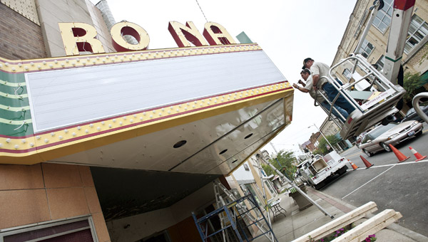 the tribune/jessica st. james Employees from Paris Signs, of Huntington, W.Va., install the marquee Ro-Na marquee Wednesday in downtown Ironton.