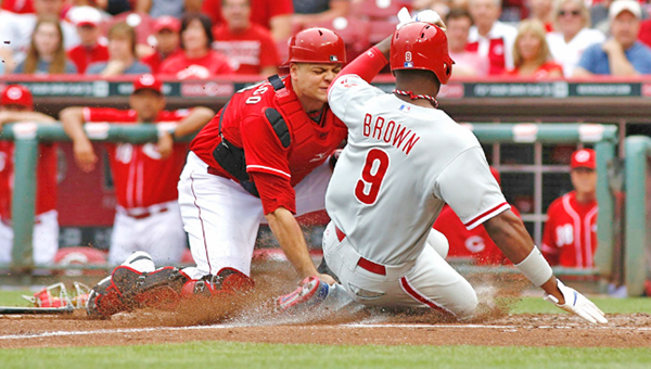 Cincinnati Reds’ catcher Devin Mesoraco (left) tags out Domonic Brown (9) at home in the fourth inning of Sunday’s game. The Reds beat the Philadelphia Phillies 4-1. (Courtesy of The Cincinnati Reds.com)