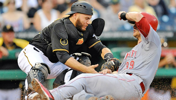 Cincinnati’s Devin Mesoraco (right) slides safely into home plate ahead of the tag by Pittsburgh catcher Russell Martin to score a run during a big third inning on Wednesday. The Reds beat Pittsburgh 11-4. (Photo Courtesy of The Cincinnati Reds.com)