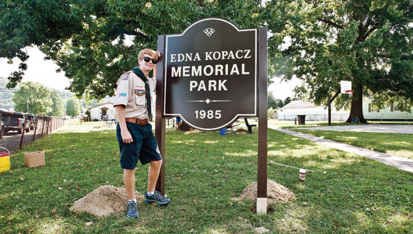Andrew David McCown stands in front of the newly erected park sign at the Edna Kopacz Memorial Park on Saturday.