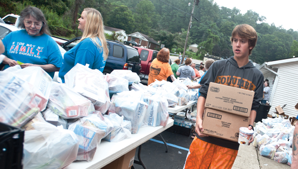 Josh Daniels carries boxes of food items during a food giveaway Saturday at Campbell Chapel Free Will Baptist Church.