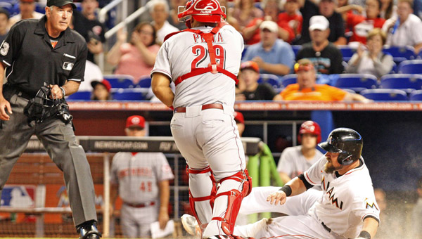 The Miami Marlins’ Casey McGehee is tagged out by Cincinnati Reds catcher Brayan Pena at home plate in the first inning at Marlins Park in Miami on Thursday. The Reds rallied to beat the Marlins 3-1. (MCT Direct Photo)