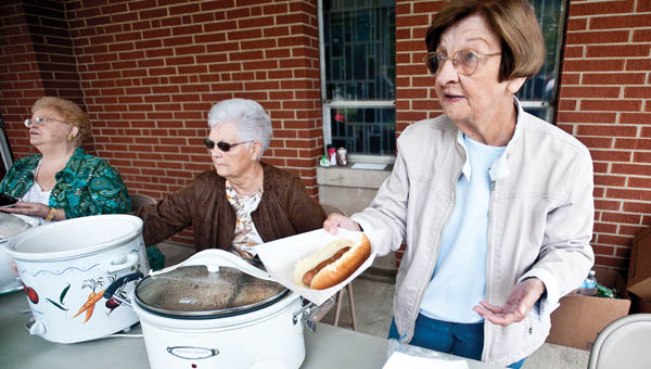 Kay Porter serves hotdogs during the annual Coal Grove Memorial United Methodist Church Block Party Saturday.