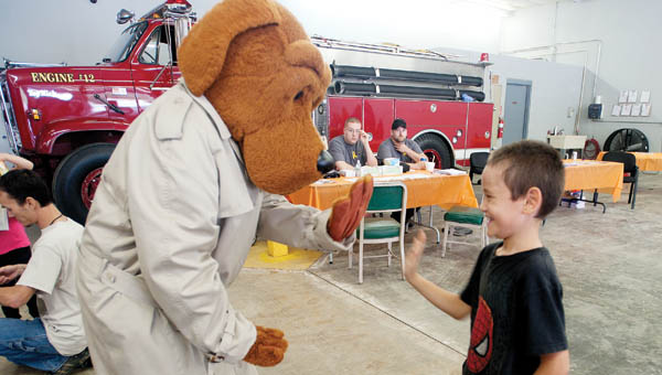 Seven-year-old Ayden Bayless gives McGruff the Crime Dog a high five during the Upper Township Fire Department Community Day event Saturday.