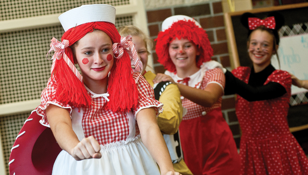 Raggedy Ann, played by Hannah Keating, leads the conga line during the Irontom High School flag corps and majorette team fundraiser Saturday in the school’s cafeteria.