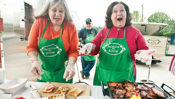 Juanita Dalton, left, and Cindy Caskey, right, serves tomato and bologna sandwiches at the Ironton Farmers Market Saturday in downtown Ironton.