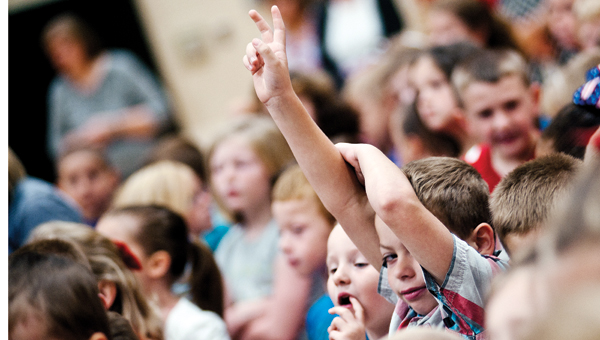 A Dawson-Bryant Elementary School student throws up the peace sign on Thursday at the start of a Patriot Day ceremony.