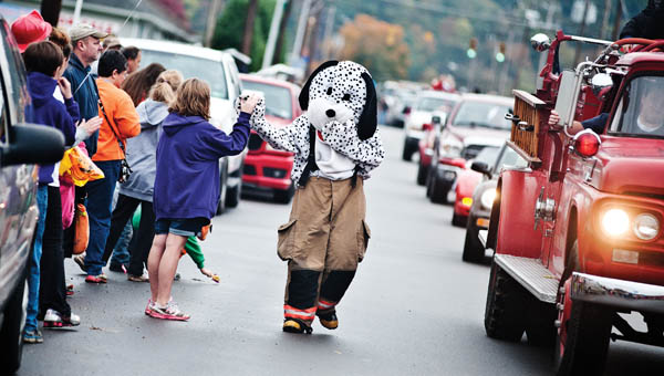 The Chesapeake Firehouse Puppy Dog high fives eventgoers during the annual Chesapeake Octoberfest parade Saturday.