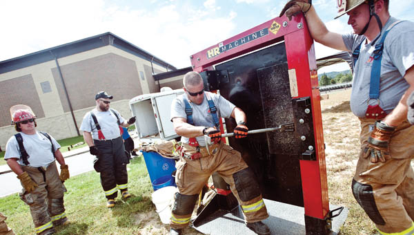 Chris Spears, with the State Fire and Rescue of Kentucky, demonstrates forcible entry techniques during fire school Saturday in South Point.