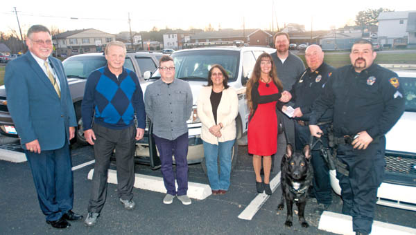 The Tribune/BRandon Roberts Members of the Dawson-Bryant Board of Education presented Coal Grove Police Chief Eric Spurlock with a check for $3,000 toward the purchase of the department’s new drug dog. Pictured, back from left, is Dawson-Bryant Superintendent Steve Easterling, board members Jim Beals, Brady Harrison, Debbie Drummond, board president Jamie Murphy, treasurer Brad Miller, Spurlock and Coal Grove police officer Mike Delawder, with Jango.