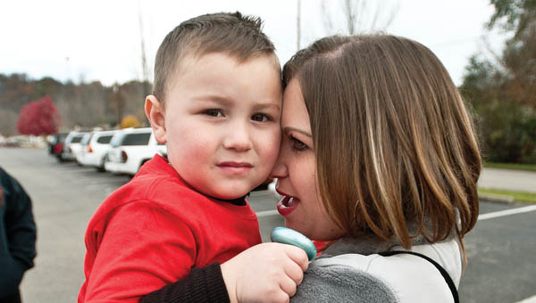 Tina Webb snuggles with her son Miles before heading down to the Joe Swartz Sports Complex for a special game Saturday.